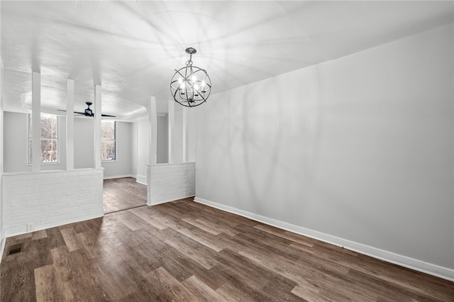 unfurnished dining area featuring ceiling fan with notable chandelier and hardwood / wood-style flooring