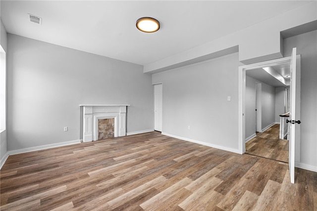 unfurnished living room featuring a fireplace and wood-type flooring