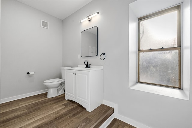 bathroom featuring hardwood / wood-style floors, vanity, plenty of natural light, and toilet