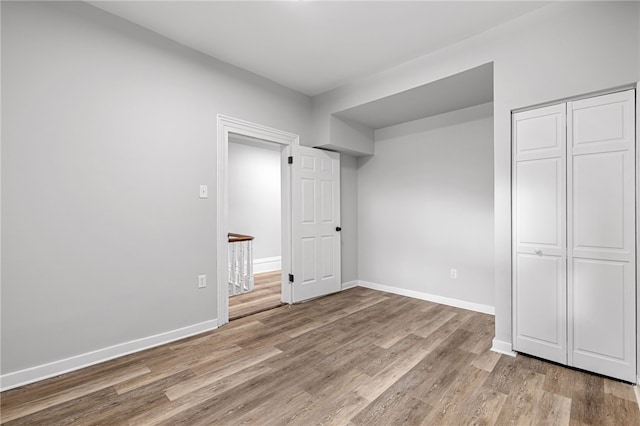 unfurnished bedroom with a closet and light hardwood / wood-style flooring