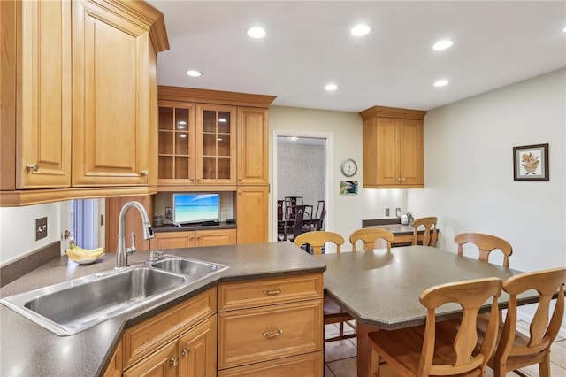 kitchen with a breakfast bar, sink, and light tile patterned floors