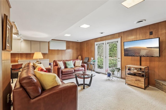 carpeted living room featuring wooden walls