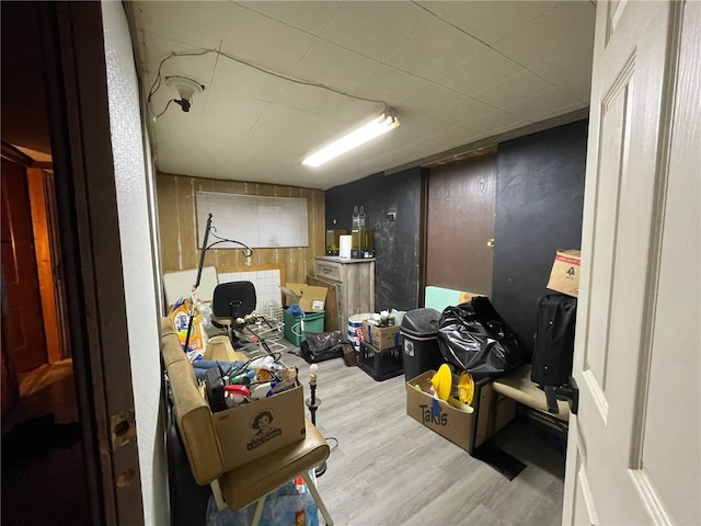 basement with wood walls and light hardwood / wood-style floors