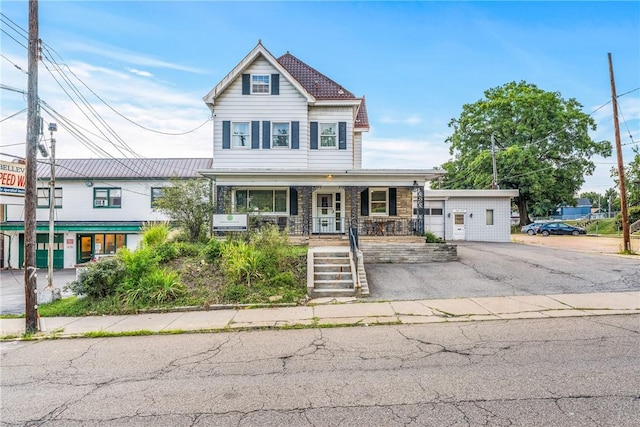 view of front of home featuring a porch and an outdoor structure