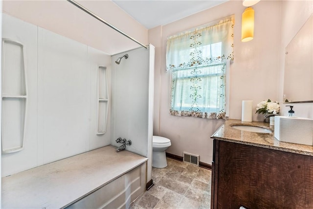 bathroom featuring vanity, toilet, and a shower