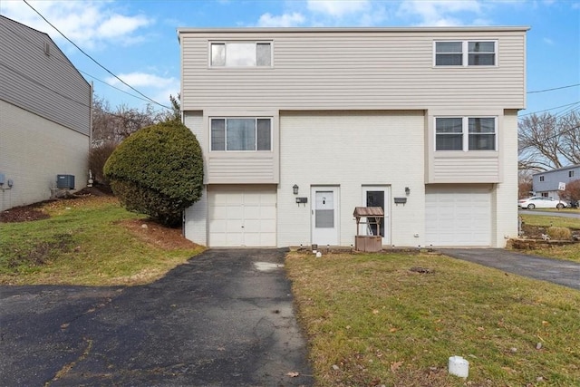 view of front facade featuring cooling unit, a garage, and a front yard