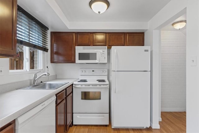 kitchen with white appliances, light hardwood / wood-style flooring, and sink