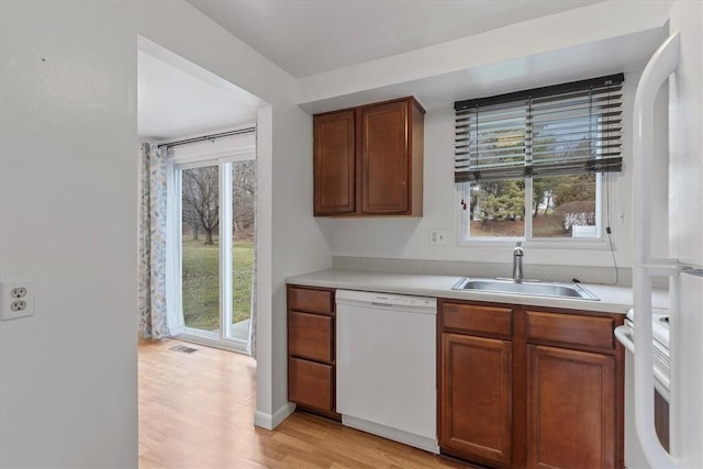 kitchen featuring a wealth of natural light, sink, and white dishwasher