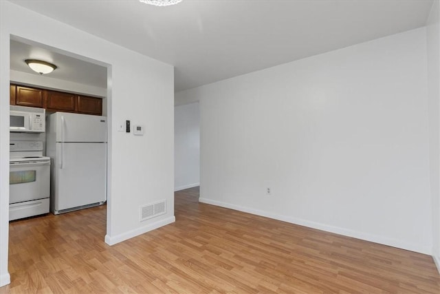 interior space with light hardwood / wood-style floors and white appliances