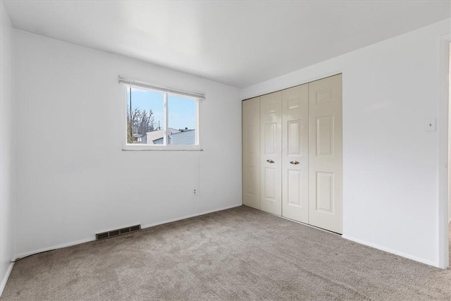 unfurnished bedroom with a closet and carpet floors