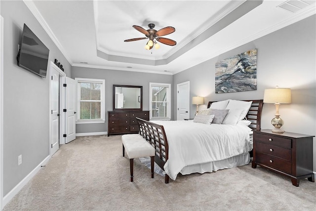 carpeted bedroom with ceiling fan, ornamental molding, and a tray ceiling