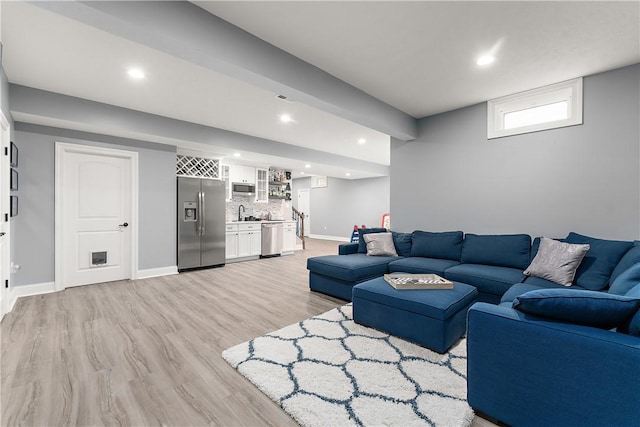 living room featuring sink and light hardwood / wood-style floors