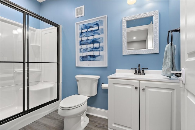 bathroom with vanity, hardwood / wood-style floors, toilet, and walk in shower