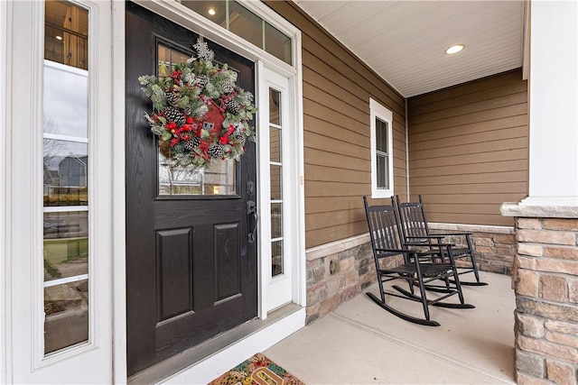 view of exterior entry featuring covered porch