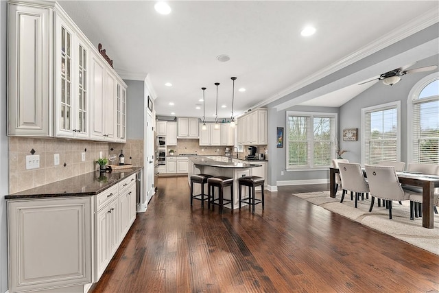 kitchen featuring white cabinetry, a breakfast bar, a kitchen island, and pendant lighting