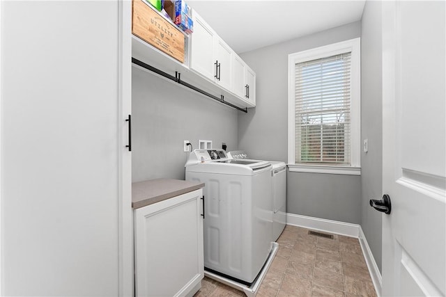 washroom with cabinets, washing machine and dryer, and plenty of natural light