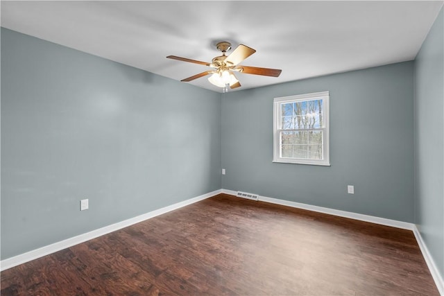 empty room featuring ceiling fan and dark wood-type flooring