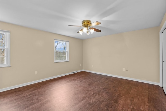 spare room featuring dark hardwood / wood-style flooring and ceiling fan