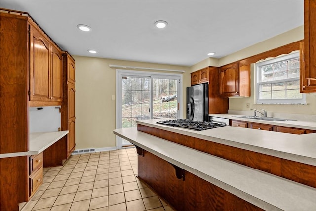 kitchen with light tile patterned flooring, stainless steel appliances, and sink