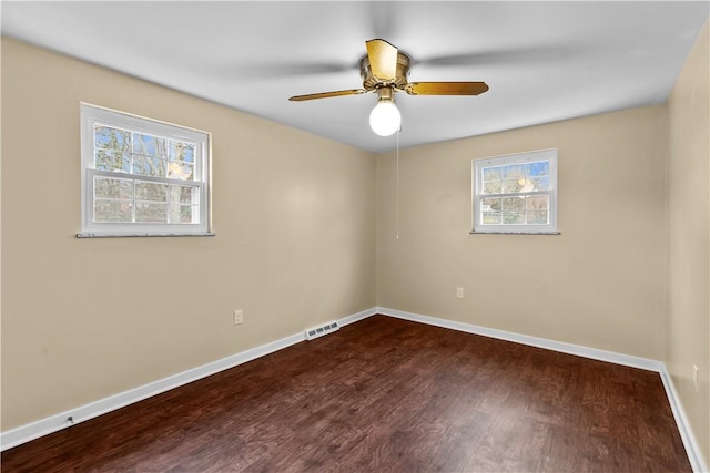 empty room with ceiling fan and dark hardwood / wood-style floors