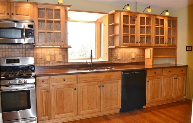 kitchen featuring decorative backsplash, sink, stainless steel appliances, and hardwood / wood-style flooring