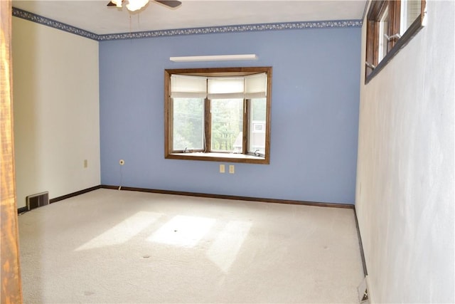 carpeted spare room with ceiling fan