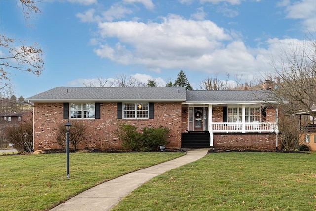 ranch-style home featuring covered porch and a front yard