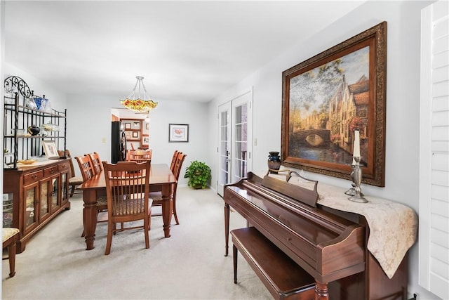 carpeted dining room featuring french doors