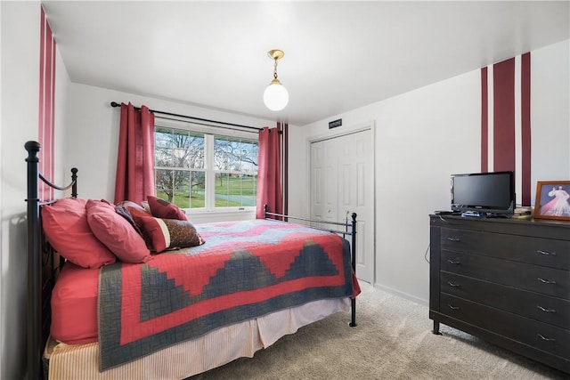 bedroom featuring light colored carpet and a closet