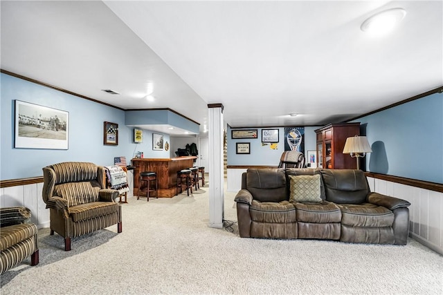 carpeted living room with ornamental molding and bar