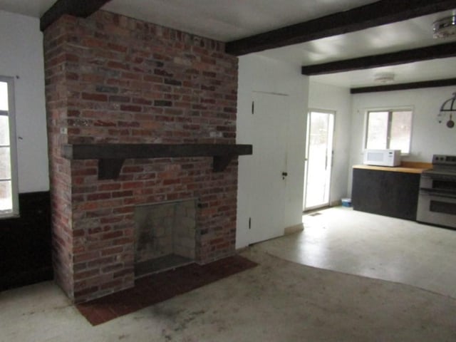 unfurnished living room with beamed ceiling and a brick fireplace