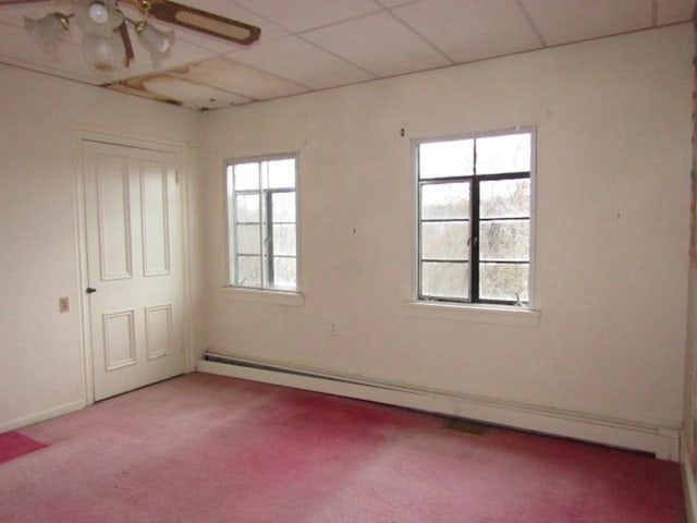 carpeted empty room with a baseboard radiator, plenty of natural light, a drop ceiling, and ceiling fan