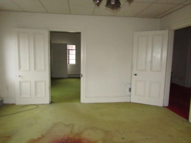 unfurnished bedroom featuring carpet and a paneled ceiling