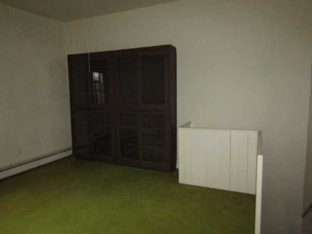 carpeted empty room featuring radiator heating unit