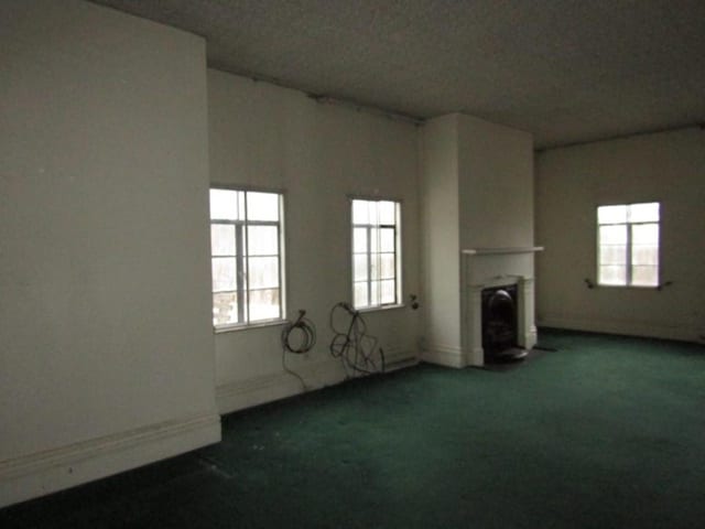 unfurnished living room with dark carpet