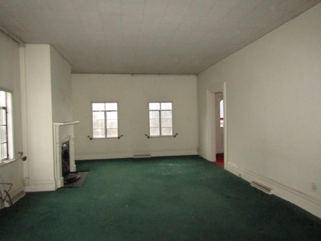 unfurnished living room featuring dark colored carpet