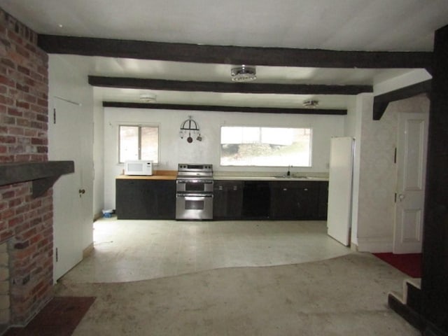 kitchen featuring beam ceiling, sink, a healthy amount of sunlight, and white appliances