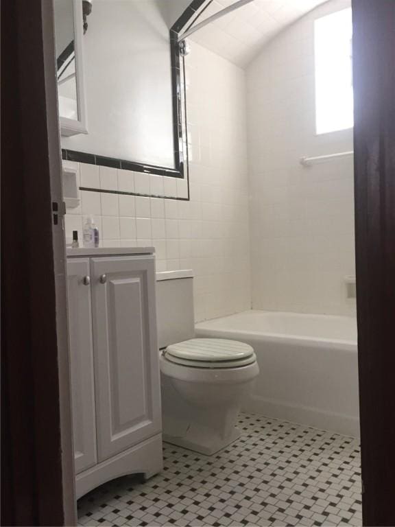 full bathroom with vanity,  shower combination, tile patterned flooring, toilet, and tile walls