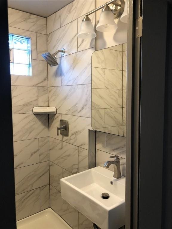 bathroom with a tile shower and sink