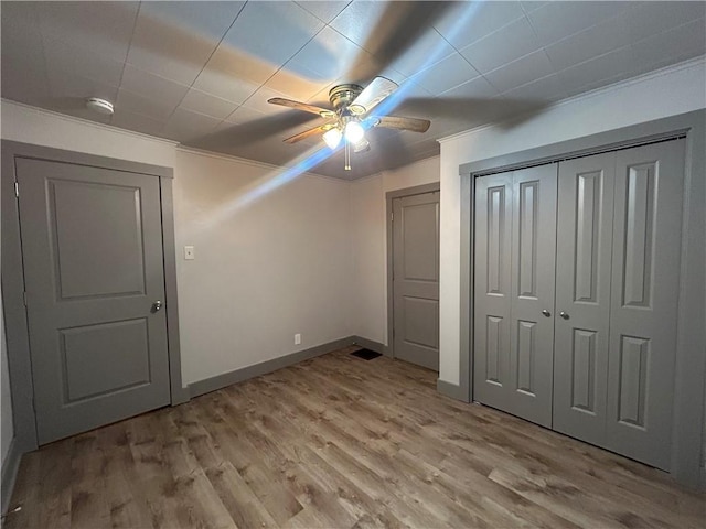 unfurnished bedroom featuring crown molding, light hardwood / wood-style floors, and ceiling fan