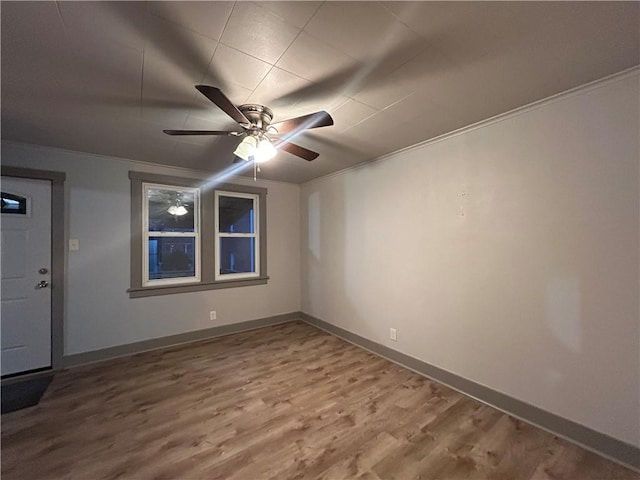 empty room with crown molding, ceiling fan, and hardwood / wood-style floors