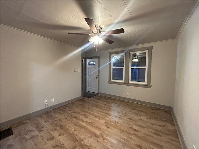 unfurnished room featuring crown molding, hardwood / wood-style floors, and ceiling fan