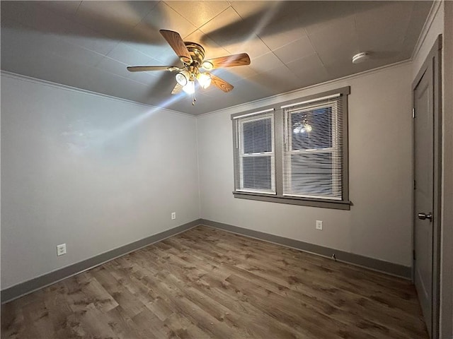 unfurnished room with crown molding, ceiling fan, and dark hardwood / wood-style flooring