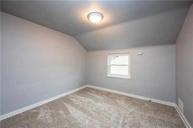 additional living space with carpet flooring and vaulted ceiling