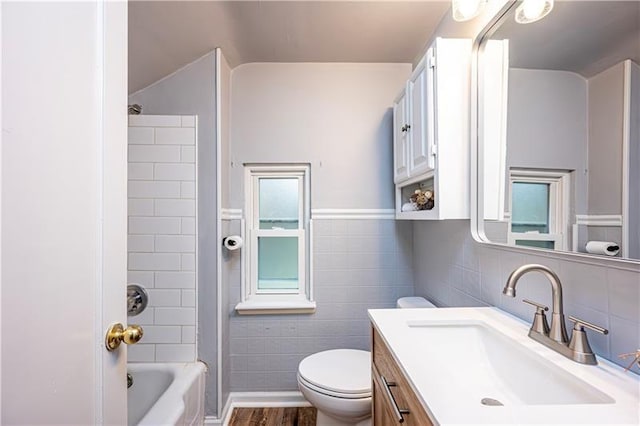 full bathroom with hardwood / wood-style flooring, a healthy amount of sunlight, toilet, and shower / tub combination