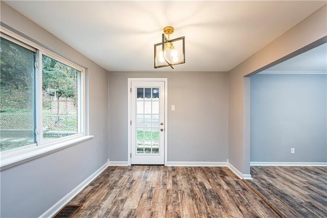 unfurnished dining area with dark hardwood / wood-style floors and a wealth of natural light