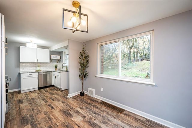 kitchen with backsplash, sink, pendant lighting, dishwasher, and white cabinets