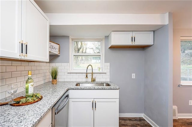 kitchen with dark hardwood / wood-style floors, light stone counters, white cabinetry, and sink