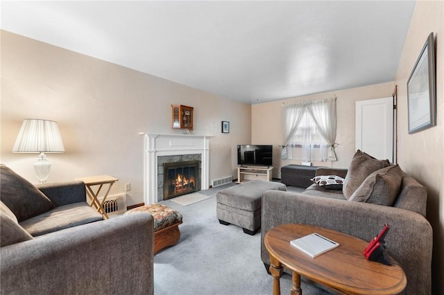 living room with a premium fireplace and light carpet