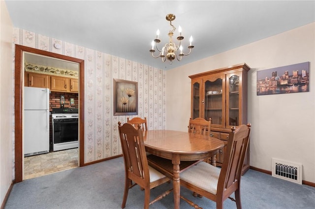 dining area featuring light colored carpet and an inviting chandelier